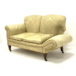 Early 20th century two seat settee with drop end, upholstered in pale gold Damask fabric, square tapering feet with brass and ceramic castors, W138cm