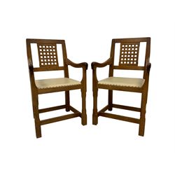 Rabbitman - pair of Yorkshire oak armchairs, the lattice back over studded hide upholstered seat, raised on faceted octagonal supports united by stretchers, carved with Rabbit signature, by Peter Heap of Wetwang