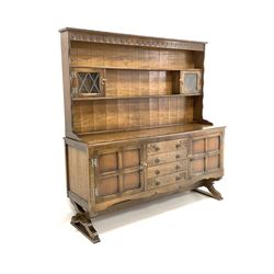 20th century oak dresser, two height plate rack with carved frieze and two lead glazed doors, over four drawers to centre and two cupboard W165cm, H171cm, D47cm