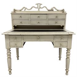 White painted Bonheur de jour or writing desk, pierced and shaped pediment, top section fitted with six drawers above inset writing surface, lower section with central frieze drawer flanked by two short drawers, raised on turned and tapering octagonal supports
