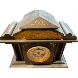 French - late 19th century 8-day Belgium slate mantle clock c1880, with a gable pediment and brass repoussé frieze beneath with a depiction taken from Greek mythological antiquity, dial flanked by recessed reeded pillars on a rectangular plinth with incised chasing, two part enamel dial with Arabic numerals and fleur di Lis steel hands,  rack striking French movement, striking the hours and half hours on a coiled gong. With pendulum.