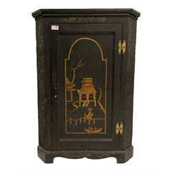 18th century black lacquered pine corner cupboard, the panelled door decorated with traditional scenes in raised gilt, pagoda building in the distance with figure and fisherman in a boat, fitted with two shelves, on bracket feet