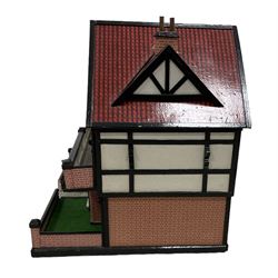 Large Tudor style dolls house, with painted and brick paper facade, balustraded balcony running the entire front, a walled garden to the front and open back revealing six rooms over two levels, W88cm, H63cm, D58cm 