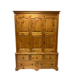 Pine wardrobe, the projecting cornice over two doors, opening to reveal interior fitted for hanging over three short and two long drawers, raised on bracket supports W157cm, H211cm, D63cm 