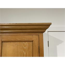 19th century ash housekeepers cupboard, the projecting cornice over four panelled cupboards, the interior fitted with two fixed shelves, the base fitted with three short and four long drawers, on a plinth base