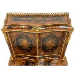 Early 20th century inlaid Kingwood Bonheur de jour, the raised gallery back with shaped cavetto moulded top mounted by cast gilt metal cartouches, enclosed by two doors inlaid with oval panels decorated with flowers, foliage and ribbons, two small drawers to the upper section, the shaped top inlaid with floral panels and with applied gilt metal edging, trailing rosewood band throughout, the lower section fitted with velvet slide over a single long drawer with shaped and floral inlaid facia, on cabriole supports mounted by foliate scroll and flower head castings