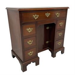 George III mahogany kneehole desk, the moulded rectangular top over one long frieze and six smaller cockbeaded drawers, with a recessed cupboard enclosing a single shelf, fitted with shaped and pierced handle plates and drop handles, lower moulding over bracket feet