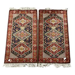 Pair of Persian ground rugs, the triple medallion with navy field enclosed by red border 205 x 97