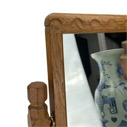 Mouseman - oak swing dressing mirror, arcade cresting rail over plain mirror plate, octagonal upright horns on sledge feet joined by stretcher, carved mouse signature, by the workshop of Robert Thompson, Kilburn