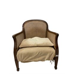20th century cane back chair with beige cushions, raised on peg feet 