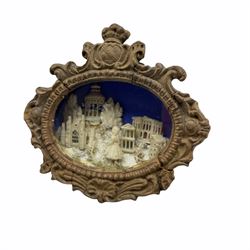 19th century small oval diorama with the figure of a girl in front of classical buildings, within a glazed case with scroll moulded frame and armorial with crown 15cm x 16cm