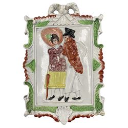Early 19th century Pearlware wall plaque circa 1820, of shaped rectangular form, decorated in relief with a Regency couple, within a scrolled border and ribbon tied pediment, W16cm x H24cm 