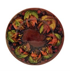 William Moorcroft plate decorated with the leaves and berries pattern, signature mark and 'Potter to H.M. the Queen' D29cm