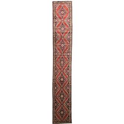 Persian crimson ground runner, the field decorated with seven floral lozenges with plain red borders, the triple-band ivory border with repeating flower head and foliate motifs