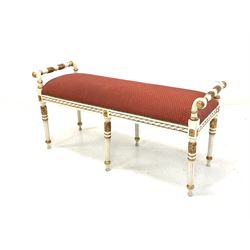 Regency design white painted parcel gilt stool, the seat upholstered in red fabric, raised on turned fluted supports W113cm
