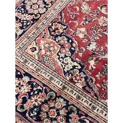 Persian Mahal red ground carpet, the field decorated all-over with scrolling branch and stylised flower head motifs, the main border band decorated with flower heads and scrolling foliage