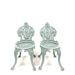 Pair of Victorian style cast iron garden chairs raised on four splayed supports with mask decoration, W46cm