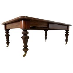 Victorian mahogany dining table, rectangular moulded top with telescopic extending mechanism, two additional leaves and winder, turned supports with carved decoration on brass and ceramic castors
