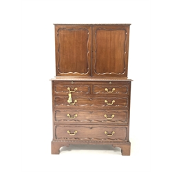 George II style cupboard on chest, the top section with two panel doors enclosing interior fitted with pigeon holes,  writing slide and two short and three long graduated drawers under, raised on bracket supports - retailed by Bertram & Son, W85cm, H138cm, D51cm.