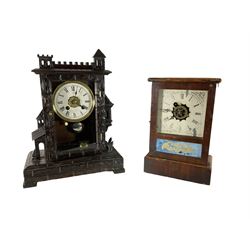 A German and American 19th century 30-hour alarm clock - German Bavarian carved case with a crenellated top and decorative turrets on a rectangular carved plinth with four pad feet, two train movement with alarm, paper dial with Roman numerals, spade hands and brass alarm setting disc to the centre, visible pendulum marked RA, sounding the alarm on a bell. H36 W27 D14.
An American 