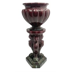 Large and impressive 19th century oxblood jardinière on stand, in the manner of Burmantofts Leeds and Massier, the fluted planter with waisted and flared rim, upon a stand modelled as three monopodial griffin with paw feet, and trefoil plinth with canted corners and moulded stiff leaf border, overall H163cm planter D65cm