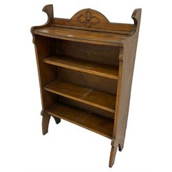 Early 20th century oak open bookcase, raised back with beaded edge and applied floral motif over two shelves