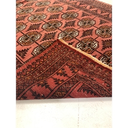 Persian Bokhara red ground rug, gul motif on red field enclosed by multi line border 