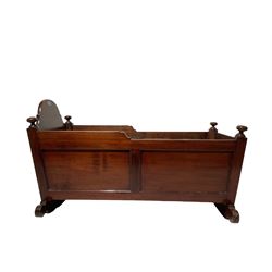 Mid-19th century mahogany cradle, rectangular tapering form with shaped headboard, applied moulded mounts, with turned finials 