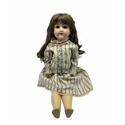 Armand Marseille bisque head doll, with open mouth, sleeping blue glass eyes, composite jointed body and brown hair, wearing a cotton dress with sequin details, spare clothes included, marked 390n A 8 N L63cm, restored in the 1980's