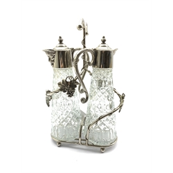 Silver plated two division decanter stand with vine decoration and two glass claret jugs with plated covers