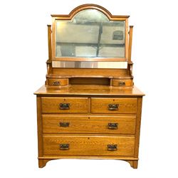 Early 20th century oak dressing chest, arched bevel edged swing mirror over open shelf and two trinket drawers, two short and two long drawers to base, raised on stile supports W107cm
