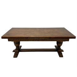 Large Jacobean design refectory dining table, rectangular draw leaf action extending top, arcade carved frieze rails, twin turned baluster supports on shaped sledge feet connected by floor stretcher 