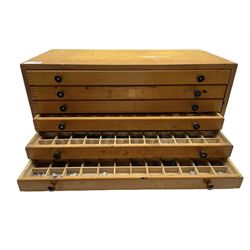 A six drawer printers chest containing a quantity of metal stamps/ matrices, H25cm, W51cm, D25cm