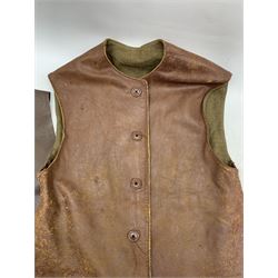 British military brown leather jerkin with khaki blanket lining L81cm x W56cm, together with two other leather waistcoats