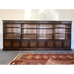 Late Victorian country house mahogany, walnut and oak dwarf breakfront bookcase, projecting cornice over frieze inlaid with figured walnut panels over eight open adjustable shelves, four fielded panelled double cupboard doors under enclosing four fixed shelves, raised on plinth base