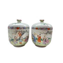 Pair of Chinese Republic Period porcelain bowls and covers, each similarly painted with a procession of boys holding objects and musical instruments in a garden setting, the fitted dome cover with double peach-form knop, iron red Qianlong Nian Zhi marks beneath, D11.5cm x H15.5cm