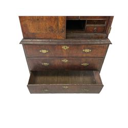 William and Mary walnut escritoire with single cushion front drawer, two doors opening to reveal interior fitted with nine drawers, one cupboard and pigeon holes over three graduated drawers, raised on bracket supports 
