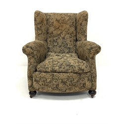 Victorian wingback upholstered armchair, with loose cushion, raised on walnut bun front supports and castors, W90cm
