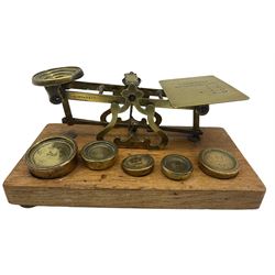 Set of brass postal scales by S Mordan & Co on an oak plinth and five brass weights