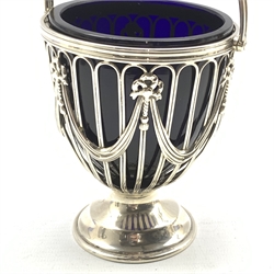 Silver sugar basket, the pierced sides with garlands and tied bows, blue glass liner and short pedestal foot, London 1913 Maker Haseler Bros