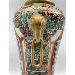 Chinese Canton style Famille Rose vase with elephant mask ring handles and slender waisted body, together with a 20th century Chinese Cloisonne baluster form vase decorated with Cranes, on ebonised stand (2)