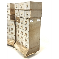 Industrial drawers - One bank of 15 stamped sheet metal industrial drawers, raised on large castors, (W70cm, H113cm, D53cm) together with another bank of 12 industrial drawers, (W70cm, H96cm, D53cm) and 12 more drawers 