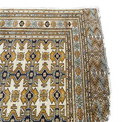 Persian pale yellow ground rug, the field decorated with interconnected geometric patterns, multiple-band border with end panels 