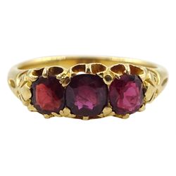 Early 20th century 18ct gold three stone garnet ring with scroll design shoulders