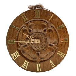'Beaverman' carved oak wall clock with a central carved Yorkshire Rose and brass Roman numerals, Quartz movement, by Colin Almack of Sutton-under-Whitestonecliffe, H20.5cm