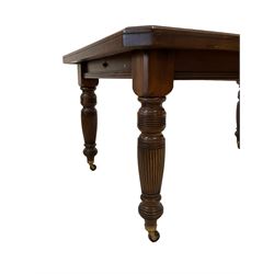 Late Victorian walnut extending dining table, canted rectangular top with moulded edge, with additional leaf and winder, on turned and fluted supports with brass and ceramic castors; together with a set of six late Victorian walnut dining chairs, shaped cresting rail carved with foliate, upholstered in cream patterned fabric, turned supports with brass and ceramic castors