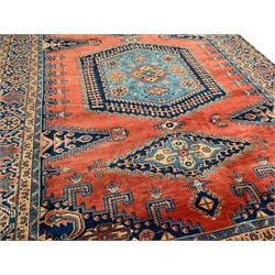 Persian Wiss red ground rug, triple medallions decorated with stylised flower head motifs, plain field with lozenge panels and spandrels decorated with Boteh and tree of life motifs, the main border decorated with repeating flower heads within multiple guard stripes