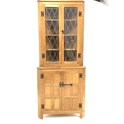 'Eagleman' oak corner cupboard,  with led glazed doors enclosing three shelves, panelled doors under enclosing another shelf, raised on block supports, W84cm, H198cm, D59cm