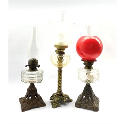 Victorian table oil lamp with glass reservoir on Art Nouveau pierced iron foot H36cm, another on gilded iron foot H34cm and one other oil lamp