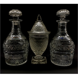 Regency cut glass sweetmeat jar and cover, hobnail cut body, domed cover on terraced square foot H25cm, together with a pair of early 19th century faceted glass mallet form decanters (3)